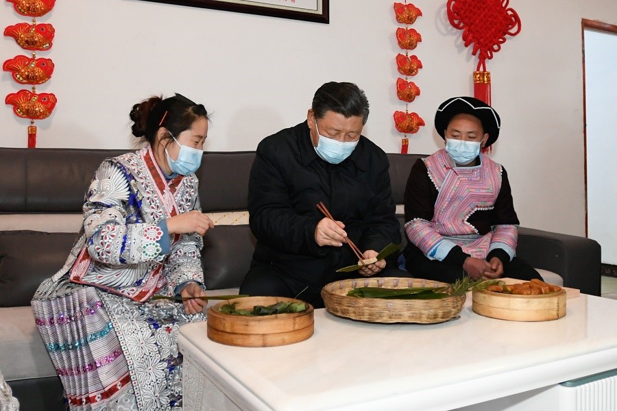 2021年2月3日下午，習(xí)近平在貴州畢節(jié)市黔西縣新仁苗族鄉(xiāng)化屋村苗族村民趙玉學(xué)家，同一家人邊聊家常邊制作當(dāng)?shù)貍鹘y(tǒng)節(jié)日食品黃粑。新華社記者 李學(xué)仁 攝
